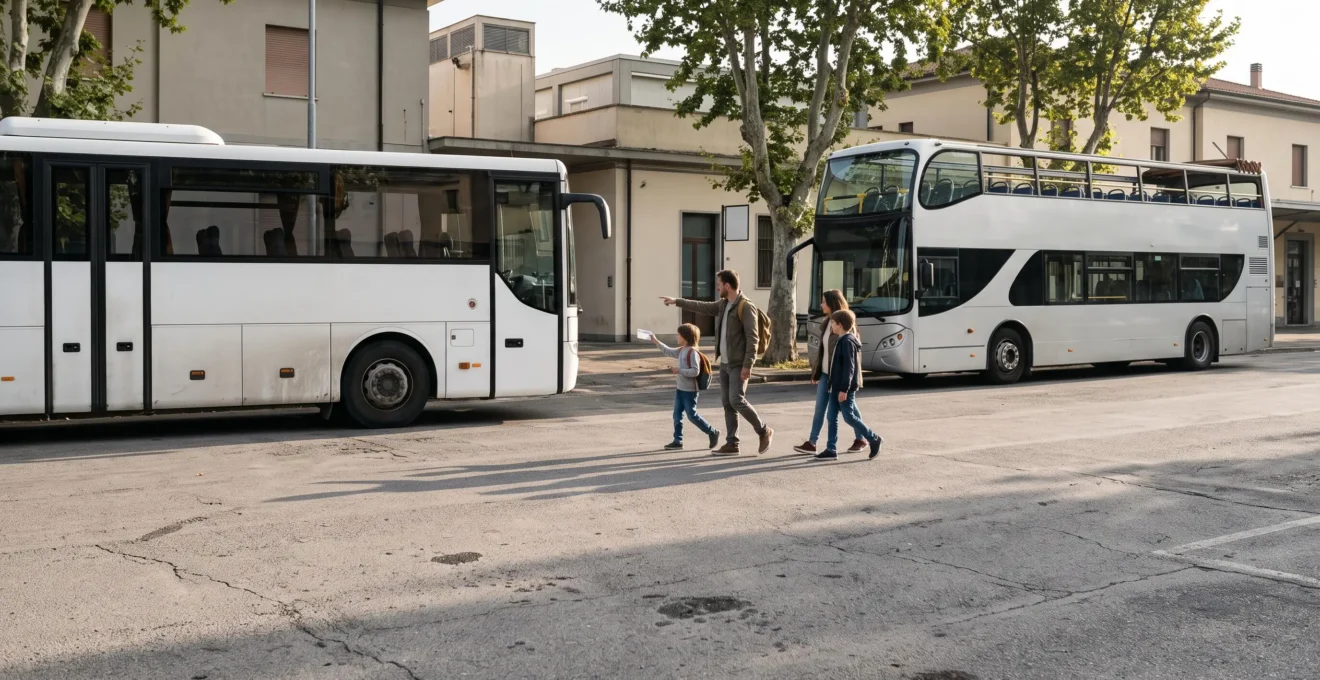 A family with two children walking toward a plain regional coach parked beside a tourist double-decker bus at a Tuscan station forecourt.